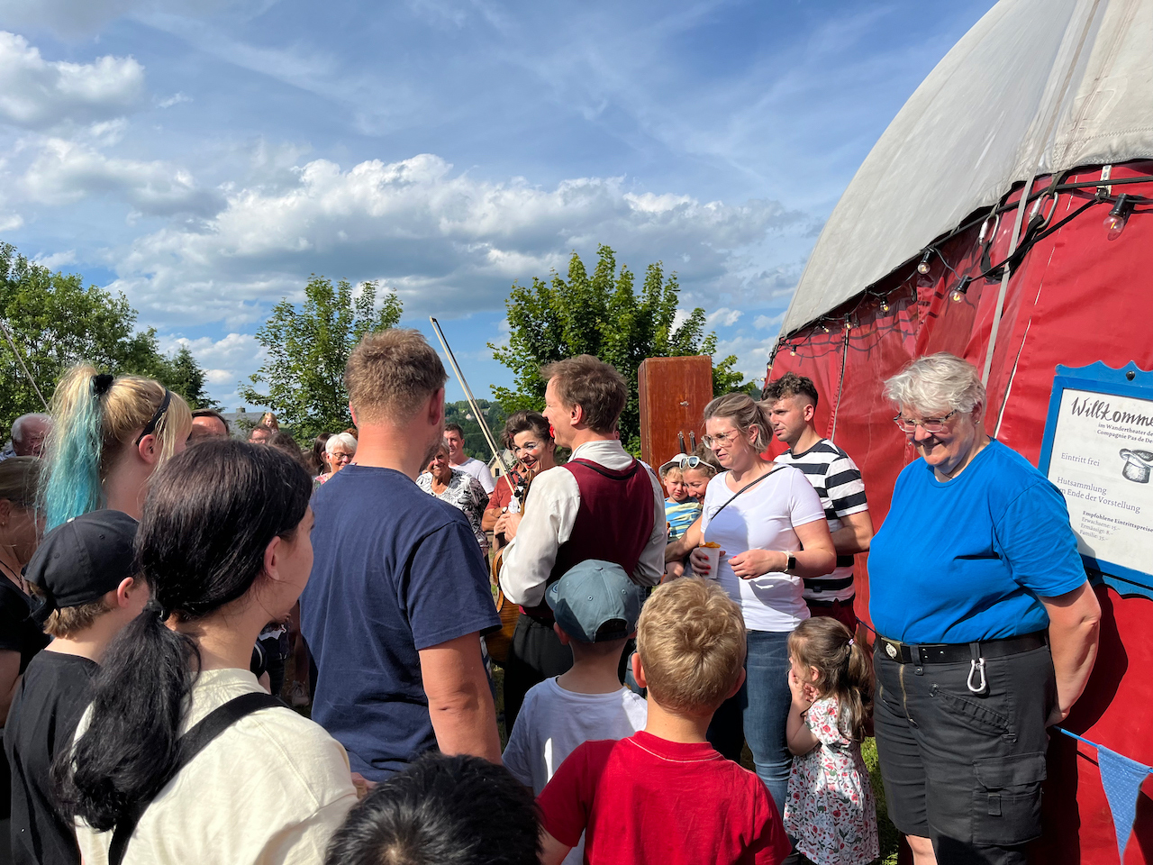Das Wetter spielt auch mit. Viele Menschen strahlen mit der Sonne um die Wette, bevor es zur Vorstellung ins Zelt geht.